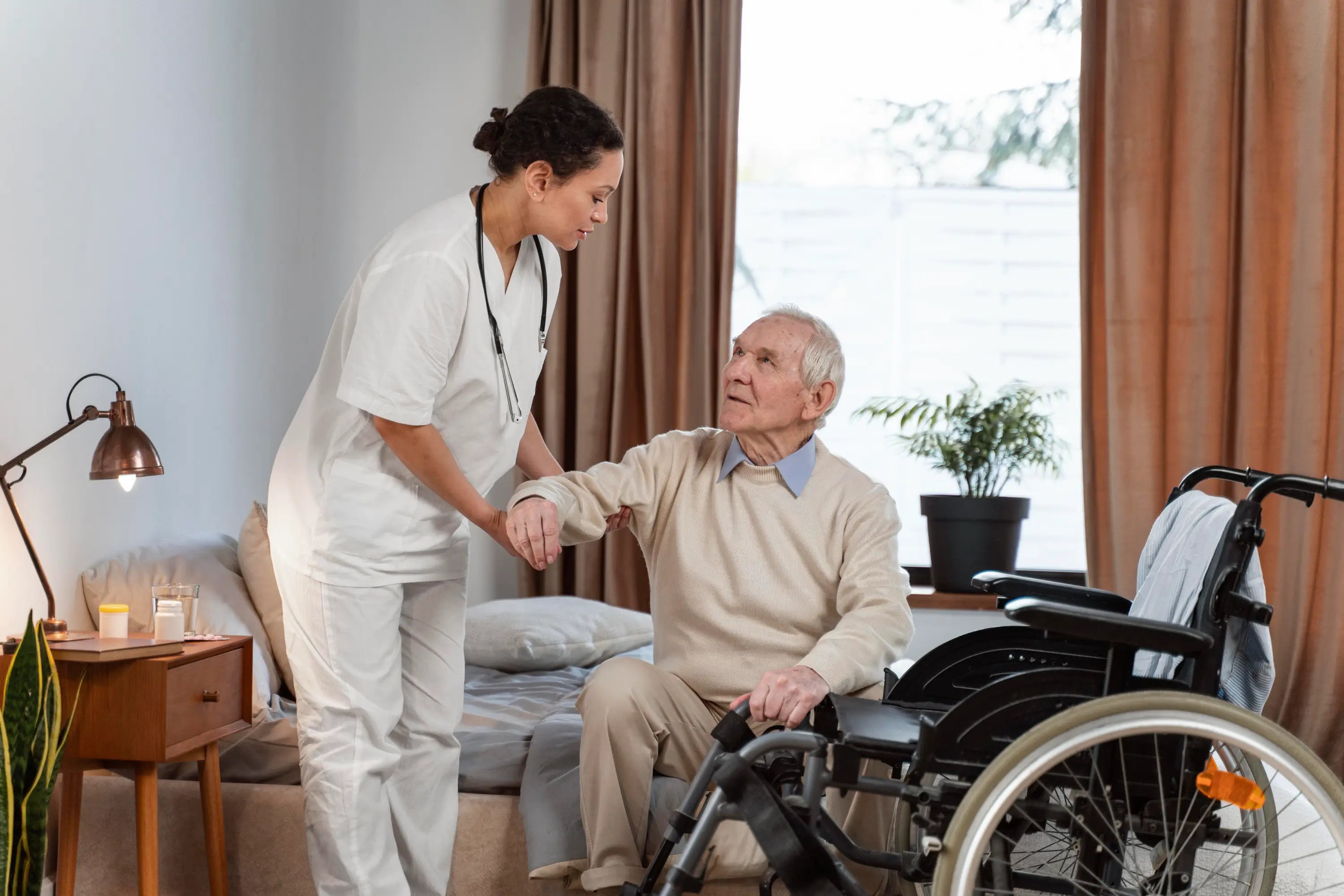 Caregiver assisting an elderly man in a wheelchair.