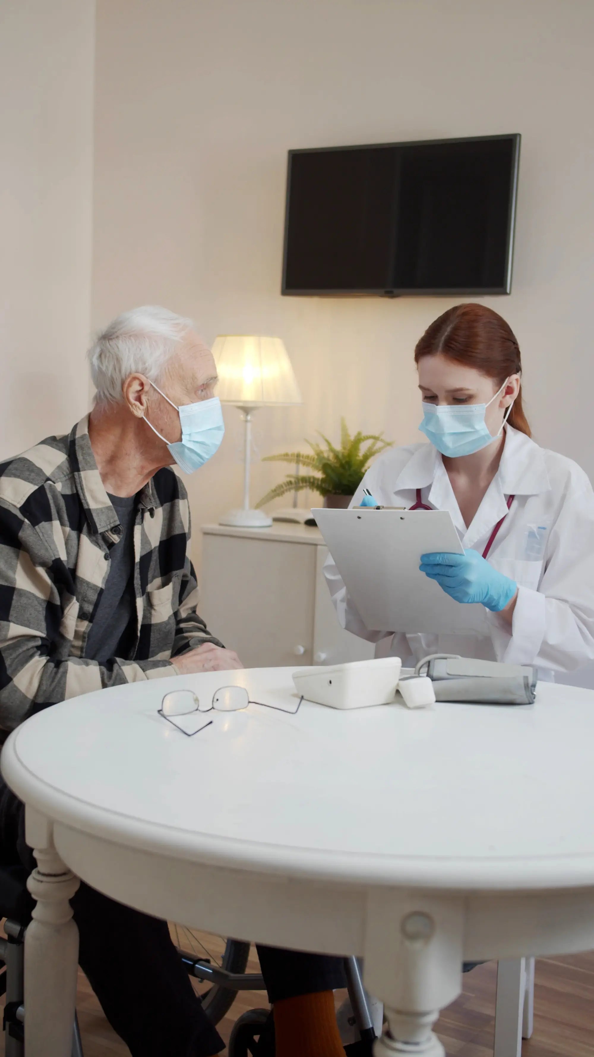 Doctor with a tablet interacting with an elderly patient in a medical setting.