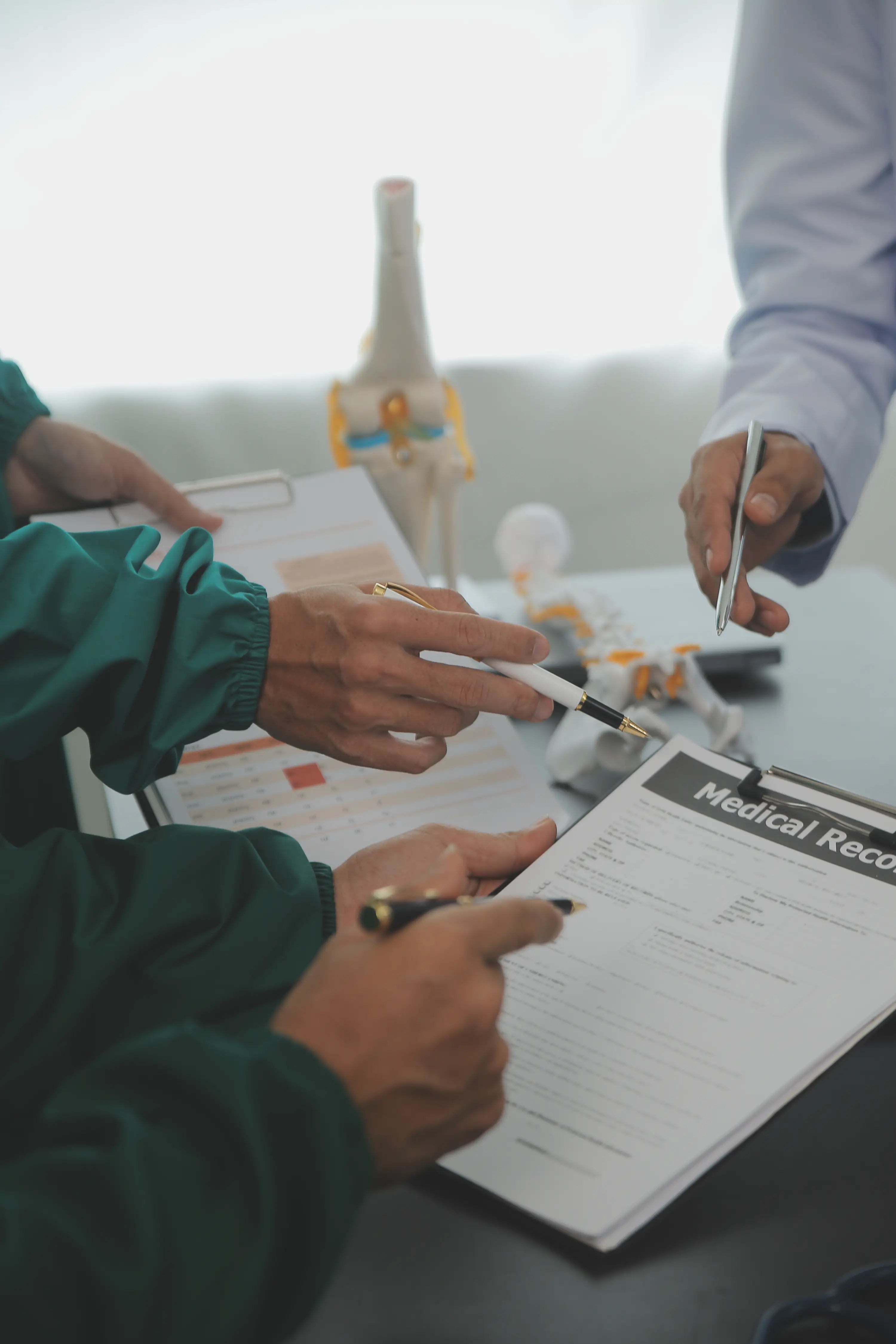 Two people reviewing medical records with a skeleton model in the background