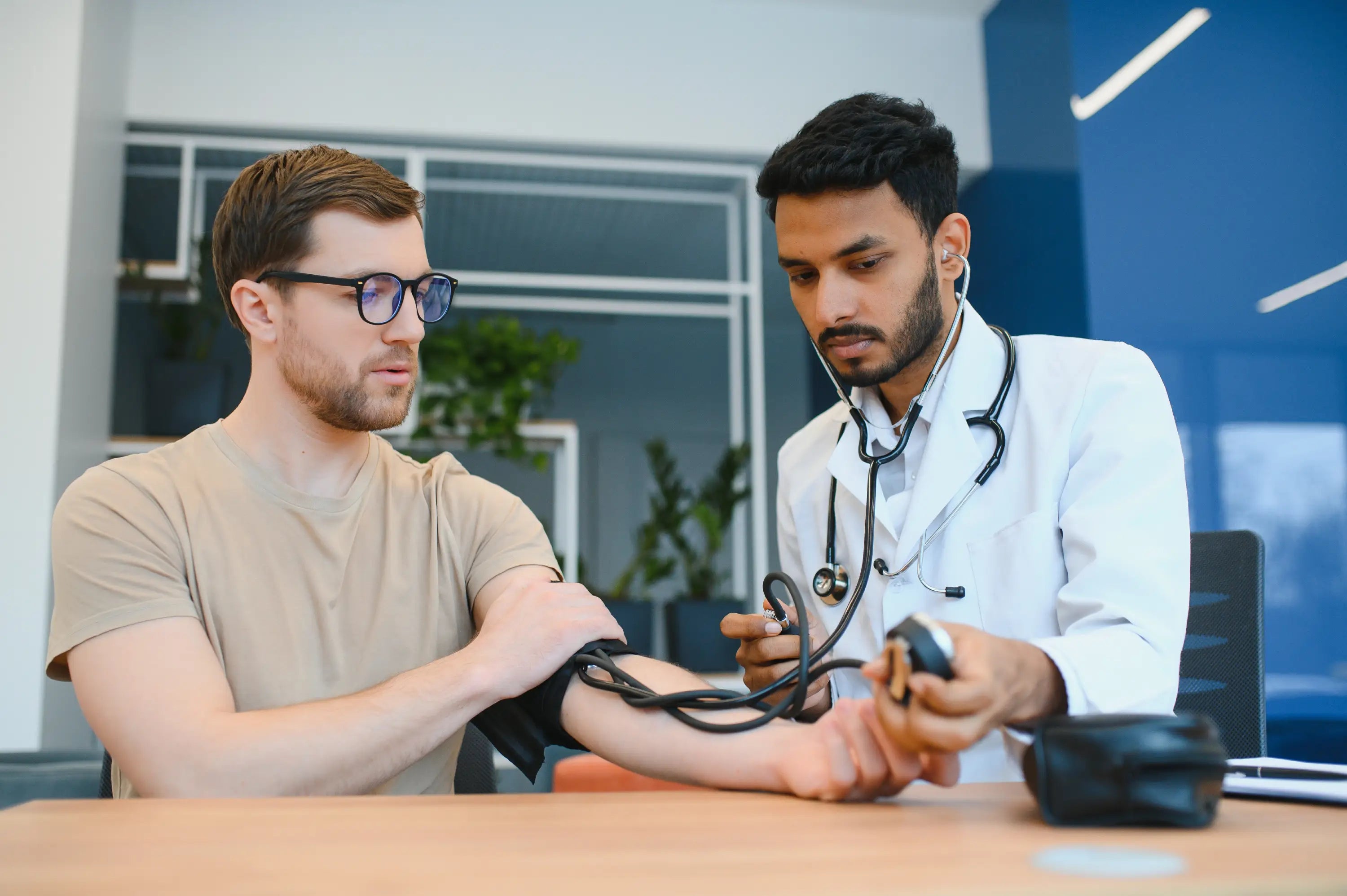 Doctor measuring a patient's blood pressure in a medical office.