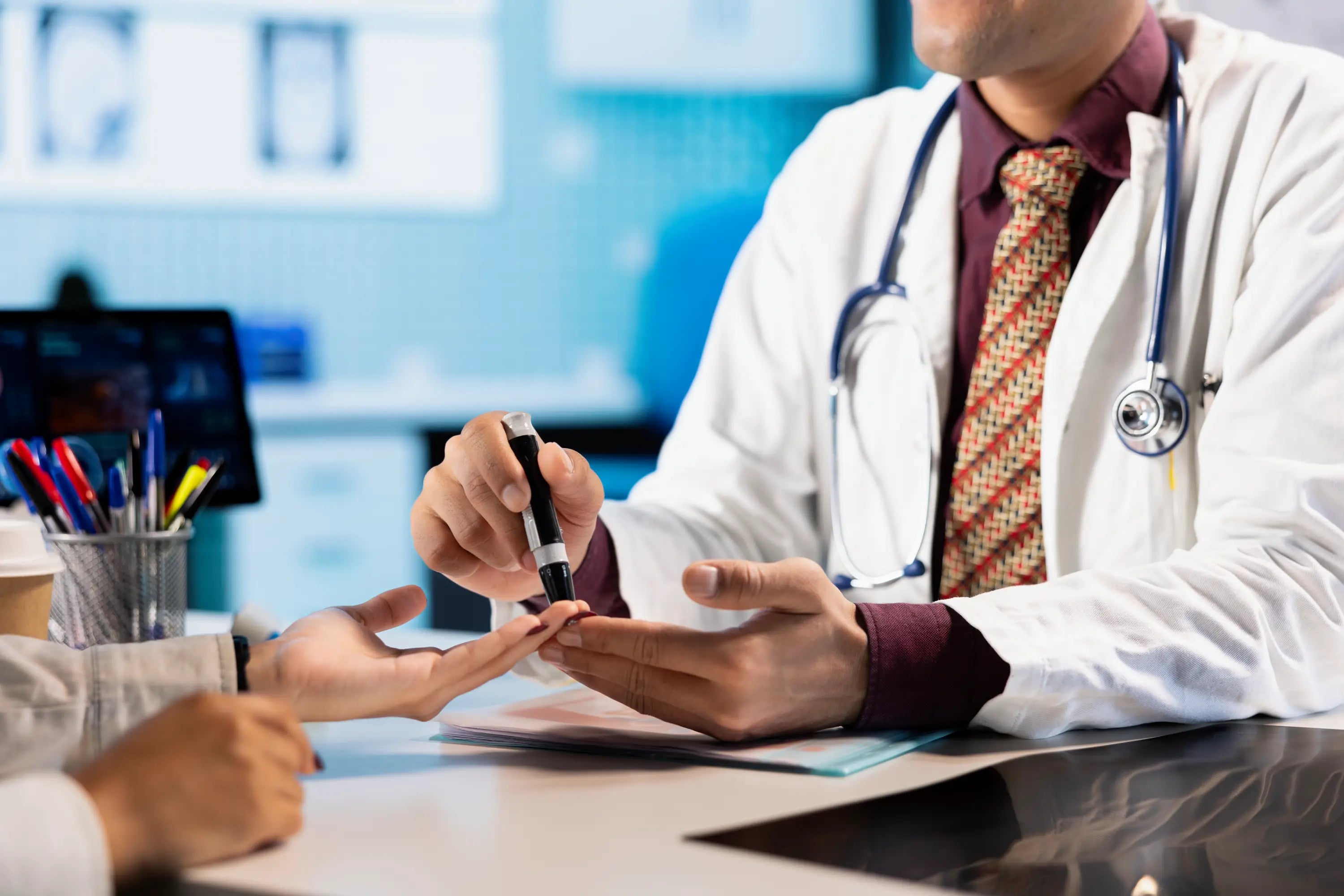 Doctor examining a patient's hand with a stethoscope around their neck.