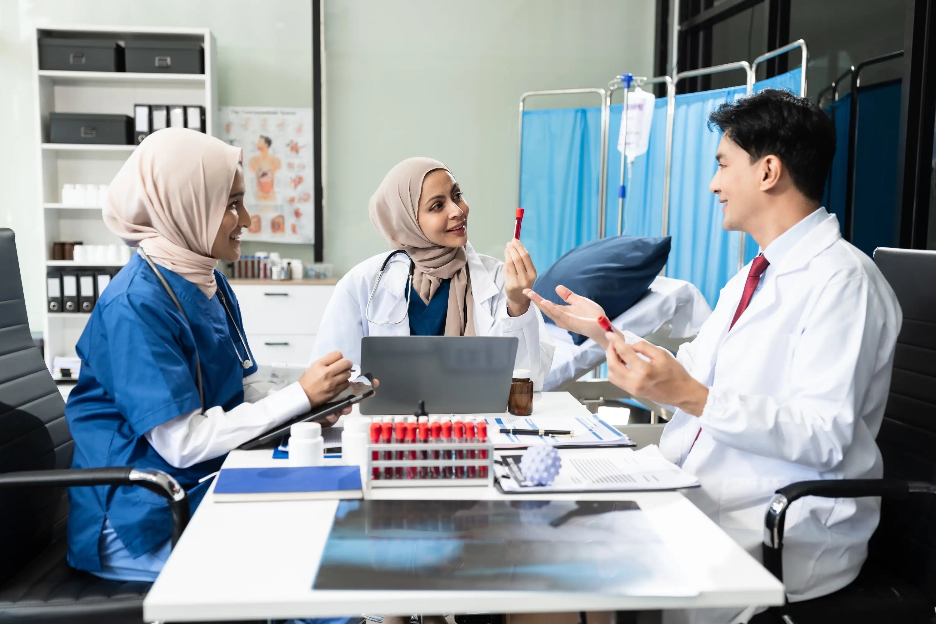 Doctors and nurses discussing patient care in a medical office setting.