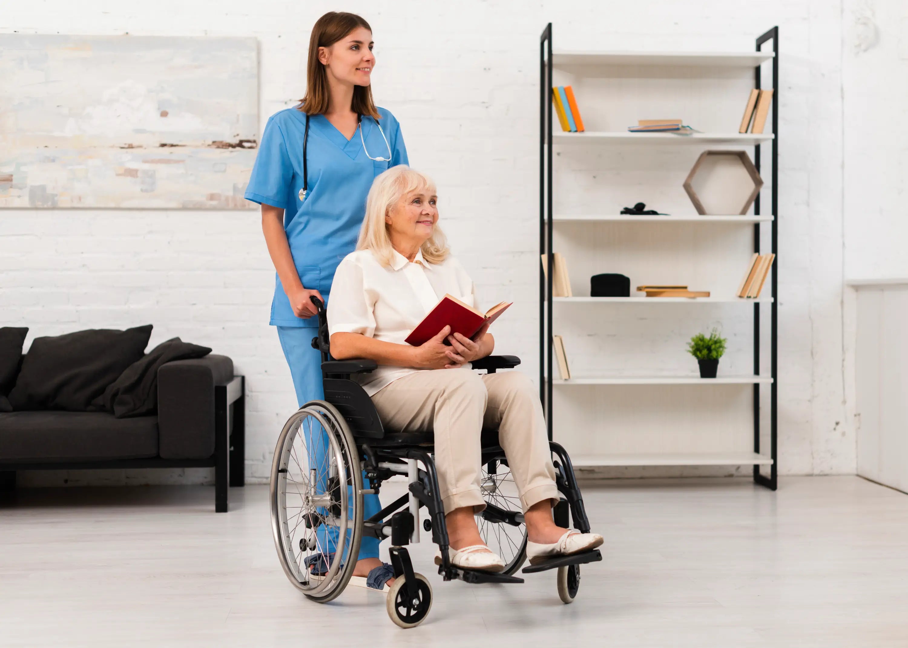 Woman in a wheelchair being assisted by a caregiver in a home setting.