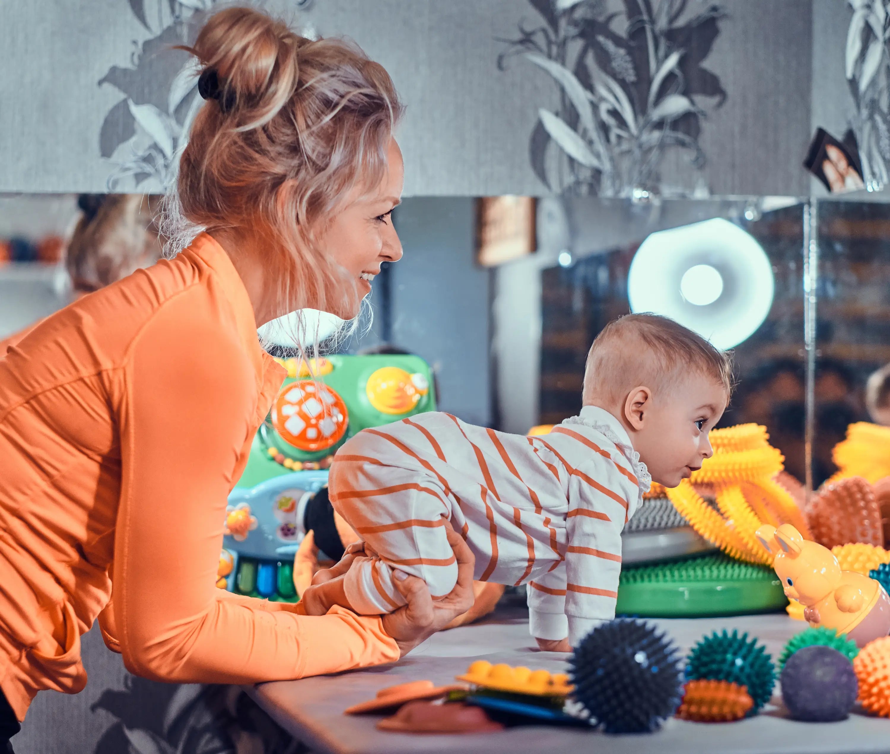 Woman and child playing with colorful toys in a room