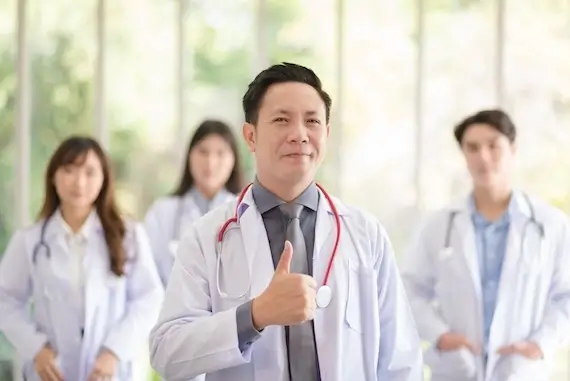 Smiling healthcare professional with a stethoscope giving a thumbs-up, representing quality home care nursing services