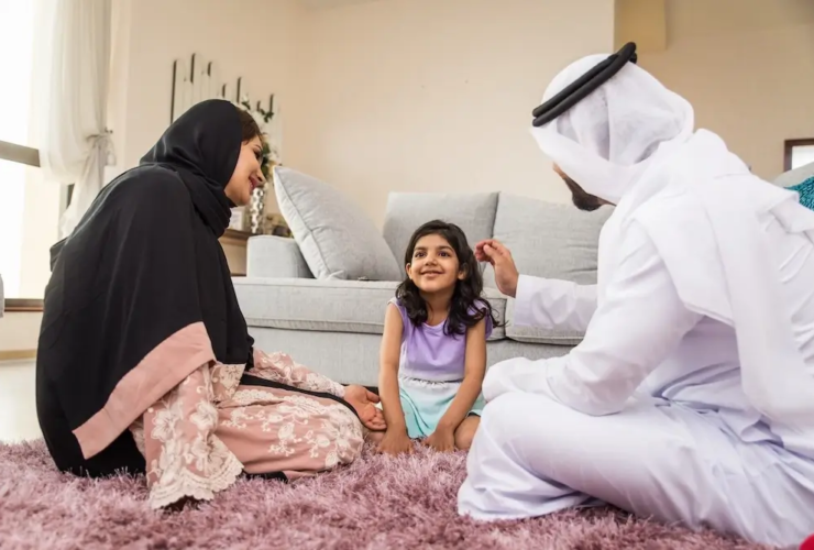 Qatar family spending quality time together at home, sitting on a rug in the living room