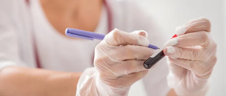 Close-up of a medical professional wearing gloves handling a blood sample in a laboratory setting.