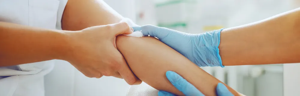 Close-up of a medical professional assisting a patient during a blood sample collection.